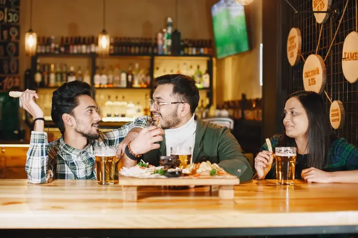 Friends chatting over drinks at a bar