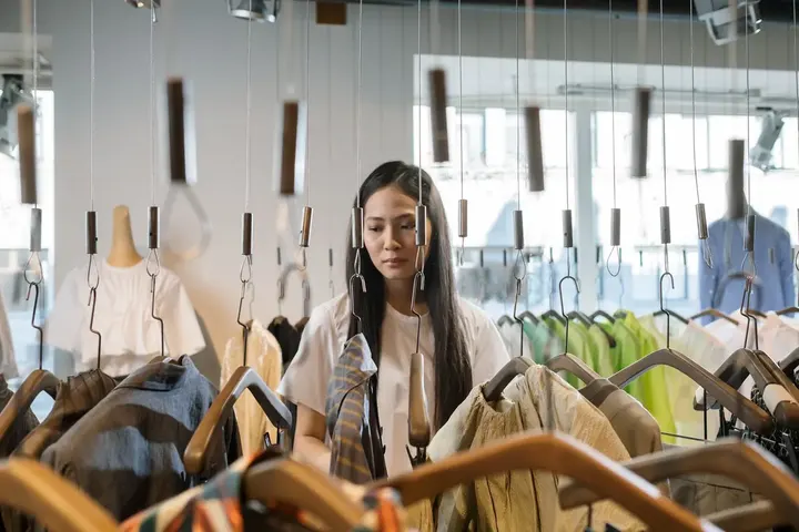 Shopper browsing a rail of clothes in a boutique